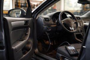 Mécanicien connectant un scanner OBD2 sous le tableau de bord d'un diesel